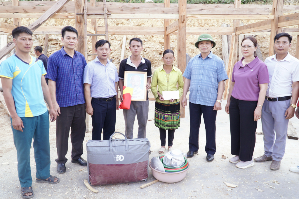 Phó Bí thư Thường trực Tỉnh ủy Triệu Đình Lê trao quà, ảnh Bác Hồ và cờ Tổ quốc cho các hộ xóa nhà tạm, nhà dột nát trên địa bàn huyện Bảo Lạc.