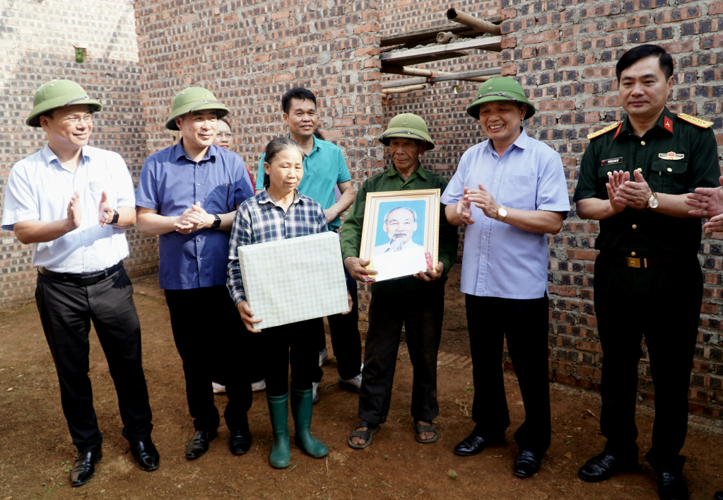 Phó Bí thư Thường trực Tỉnh ủy Triệu Đình Lê trao quà, ảnh Bác Hồ và cờ Tổ quốc cho các hộ xóa nhà tạm, nhà dột nát.